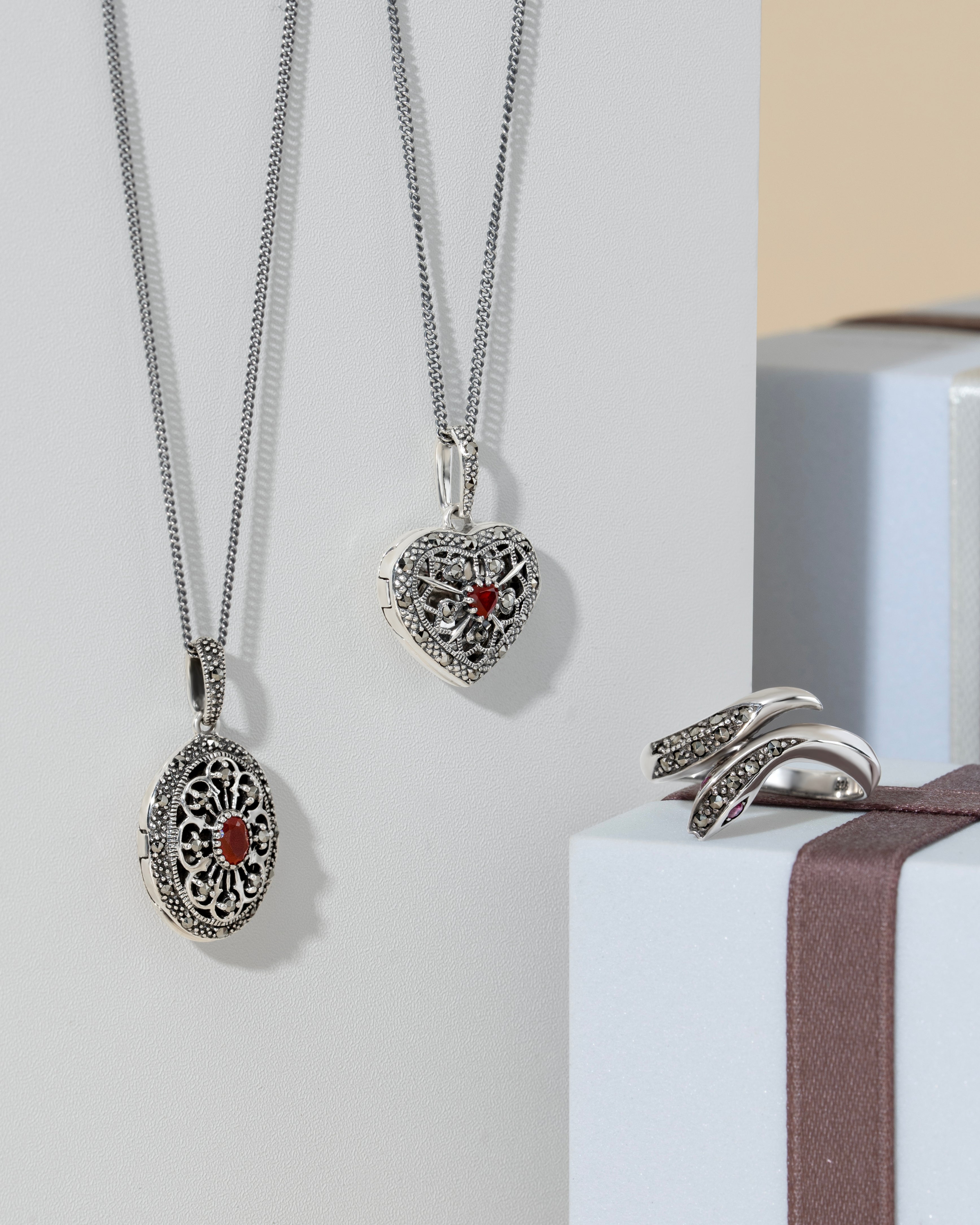 Silver necklaces with heart and oval pendants on a white background